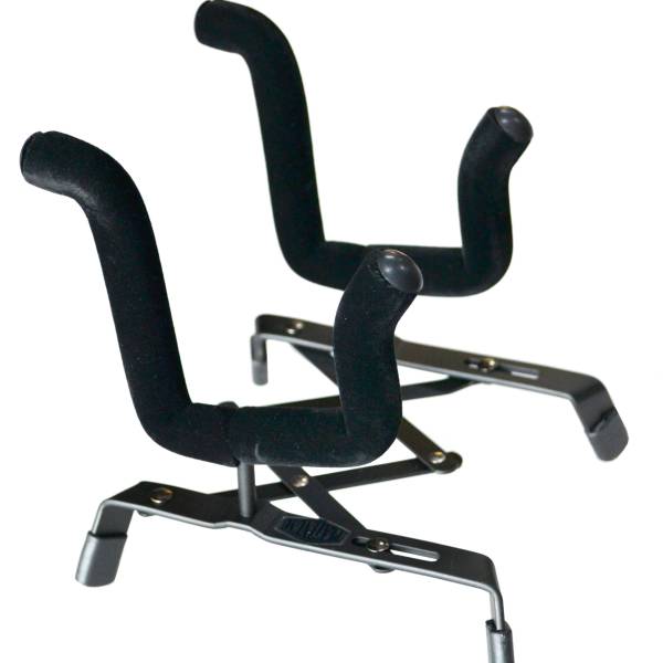A black metal concertina-style instrument stand resting on four rubber feet, featuring two wide, U-shaped support arms heavily wrapped in black protective material.