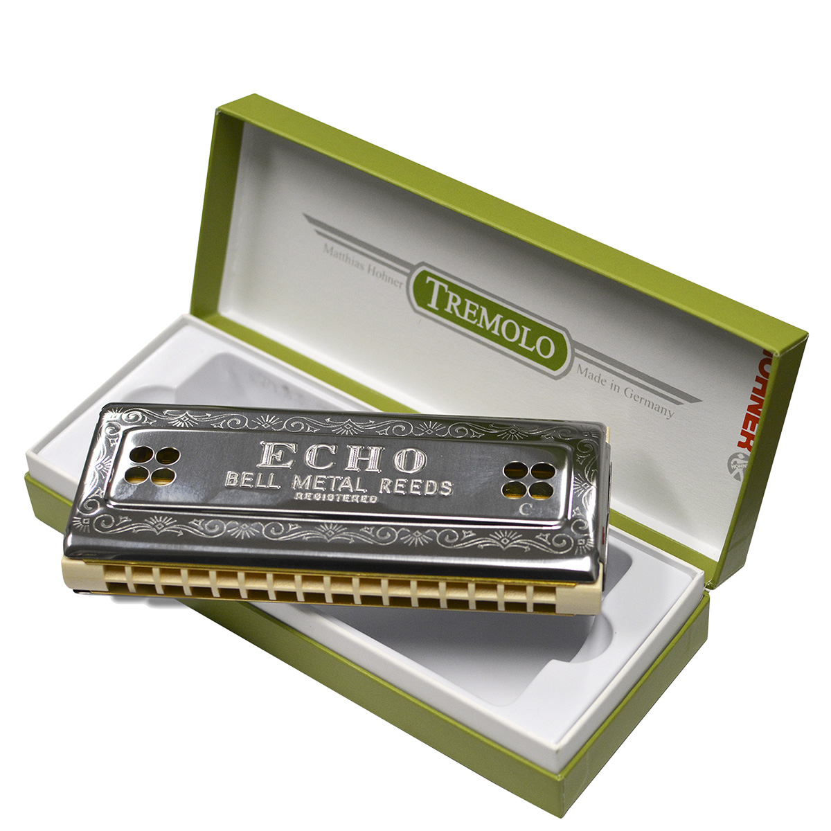 Hohner Echo double-sided harmonica resting inside a green retail box with a white interior insert.