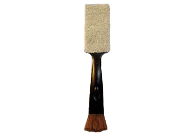 A single cleaning tool with a black handle featuring an embossed Music Nomad logo. The top of the tool holds a rectangular white microfiber pad, and the bottom ends in a brown bristle brush.