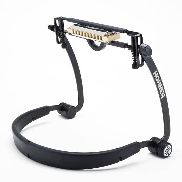 A black Hohner FlexRack harmonica neck holder supporting a gold and silver harmonica in its adjustable clamp.