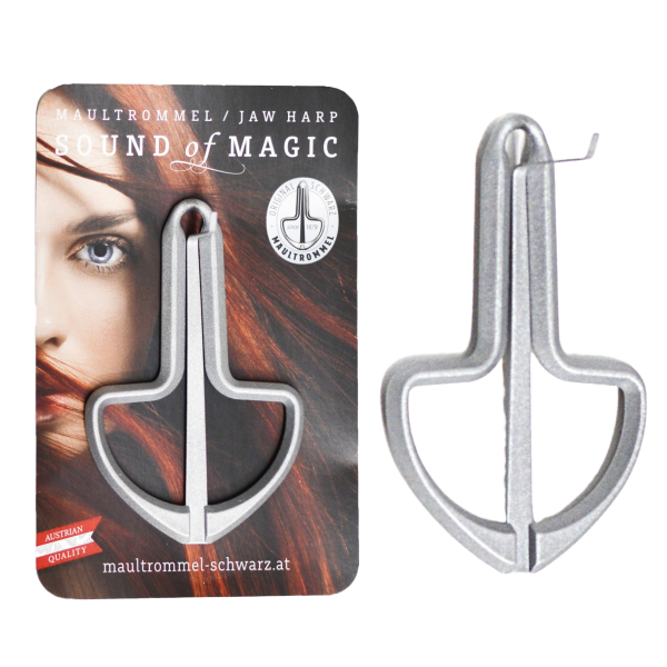 A silver metal jaw harp shown beside a retail backing card that features a printed image of a woman and has an identical jaw harp attached to it.