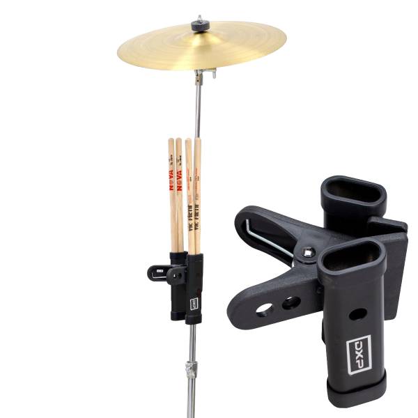 The DXP TDK085 drumstick holder attached to a cymbal stand, containing three pairs of Vic Firth Nova drumsticks, with a close-up showing the heavy-duty black clamp and dual tube construction.
