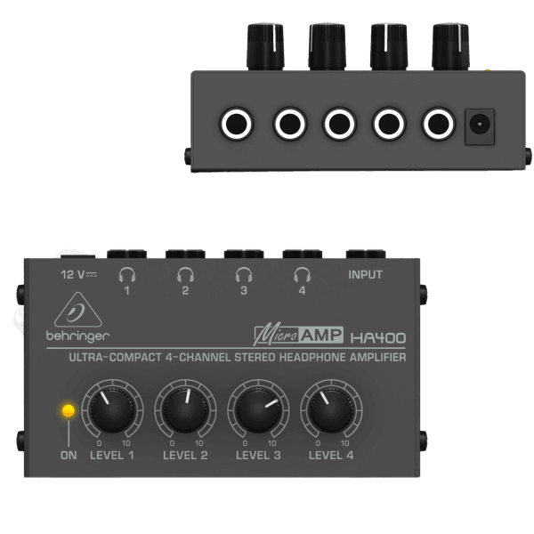 A black Behringer Microamp HA400 unit with four volume knobs, displayed next to its black AC power adapter and cable.