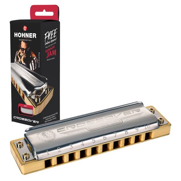 A silver Hohner Marine Band Crossover harmonica with a bamboo comb, positioned diagonally next to its vertical black retail display box featuring a portrait of Dennis Gruenling and a free online lessons promotion.