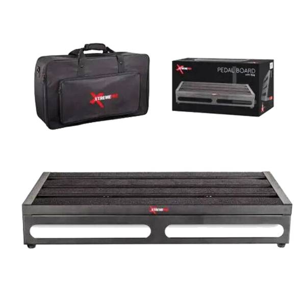 A black slotted metal pedal board shown below a physical black padded carry bag with a zipper pocket and an accompanying black retail display box featuring an illustration of the pedal board.