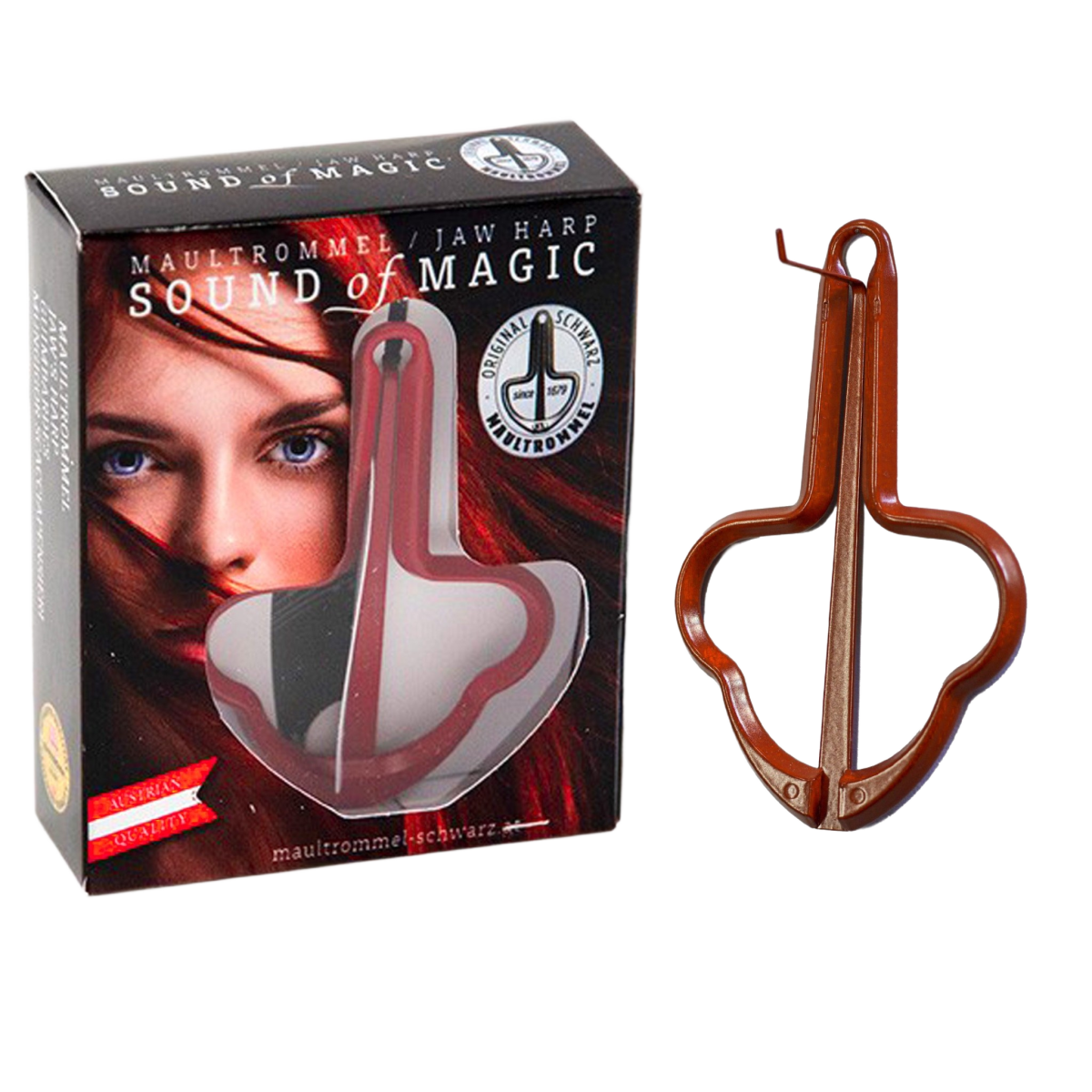 A red metal jaw harp standing upright next to its black rectangular retail display box, which features a window and printed graphics of a woman's face.