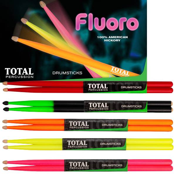 Five pairs of Total Percussion drumsticks in fluorescent red, green-to-black gradient, orange, yellow, and pink, displayed below a retail display box highlighting the Fluoro line and 100% American Hickory construction.