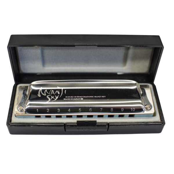 A Suzuki Manji Sky harmonica with a blue comb and silver cover plates resting inside a black hard plastic case with a blue interior lining.