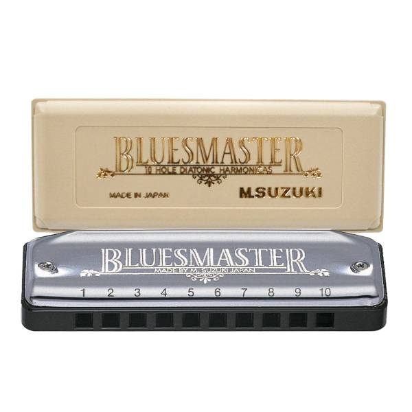 A close-up view of the Suzuki Bluesmaster MR-250C diatonic harmonica, showing its stainless steel cover plates engraved with 'BLUESMASTER' and 'MADE BY M. SUZUKI JAPAN', above numbered holes 1 to 10 on a black comb. Behind it rests its custom-fit beige hard plastic carrying case, with raised gold lettering reading 'BLUESMASTER', '10 HOLE DIATONIC HARMONICAS', and 'MADE IN JAPAN'